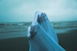 a hand with a white glove on a beach